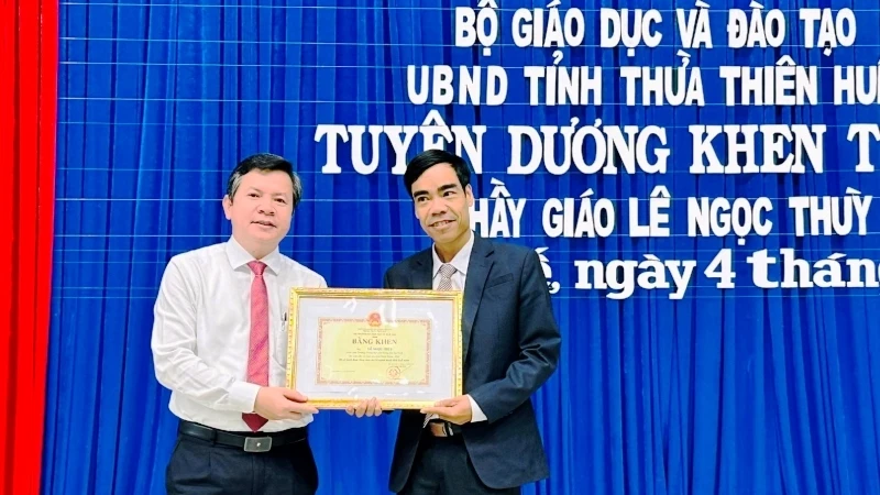 Giám đốc Sở Giáo dục và Đào tạo trao Bằng khen của Bộ Giáo dục và Đào tạo và UBND tỉnh cho thầy giáo Lê Ngọc Thùy (bên phải).