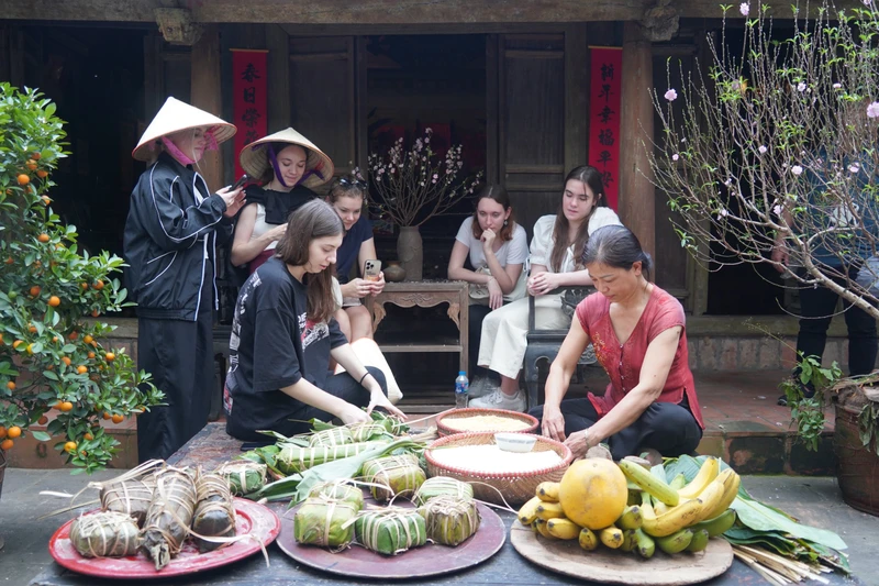 Các vị khách quốc tế trải nghiệm gói bánh chưng.