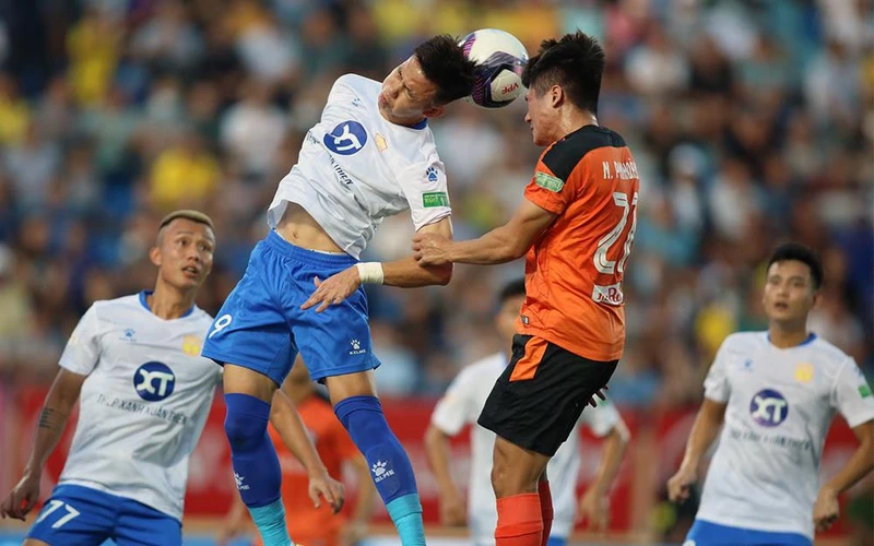 Pha tranh bóng quyết liệt giữa cầu thủ hai đội Nam Ðịnh (áo trắng) và SHB Ðà Nẵng. (Ảnh VPF) 