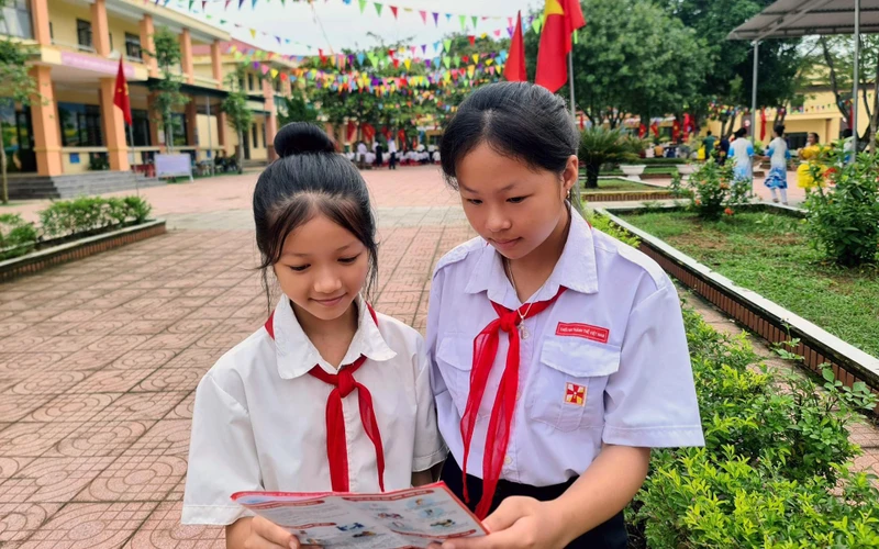 Các em học sinh tìm hiểu về quyền lợi khi tham gia bảo hiểm y tế (Hà Tĩnh). (Ảnh TÂM TRUNG) 