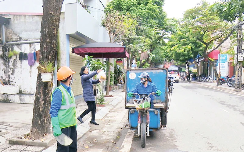 Người dân phường Ngô Quyền thực hiện đổ rác đúng giờ quy định. (Ảnh Hải Yến) 