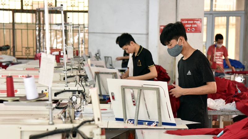 Công nhân Công ty cổ phần Nam Tiệp (Cụm công nghiệp An Xá, thành phố Nam Ðịnh, tỉnh Nam Ðịnh) may quần áo xuất khẩu. (Ảnh TRẦN HẢI) 