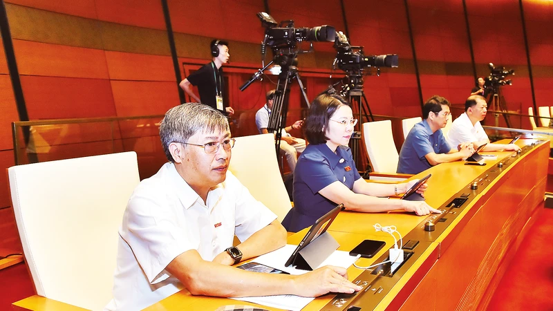 Các đại biểu Quốc hội biểu quyết thông qua Nghị quyết về Chương trình xây dựng luật, pháp lệnh năm 2024, điều chỉnh Chương trình xây dựng luật, pháp lệnh năm 2023. Ảnh: Mỹ Hà 