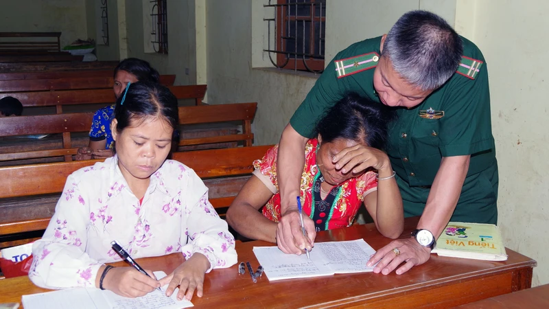 Ðại úy Nguyễn Kim Trọng hướng dẫn học viên luyện viết chữ. 
