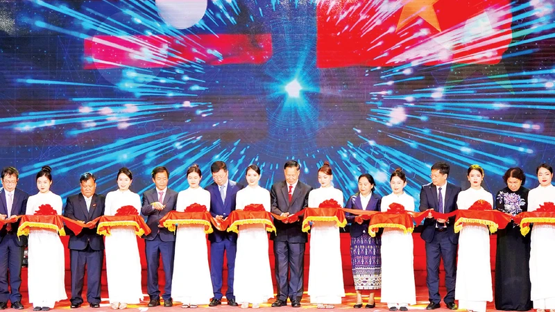 Các đại biểu cắt băng khai mạc Chương trình Ngày hội thắm tình hữu nghị đặc biệt Việt Nam - Lào năm 2023. (Ảnh CÔNG HẬU) 