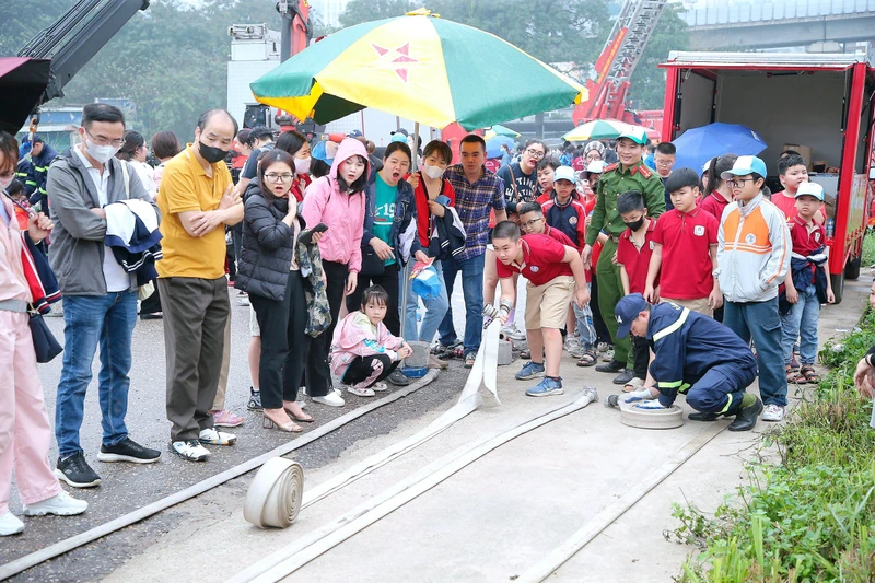 Cảnh sát PCCC và CNCH quận Thanh Xuân (Hà Nội) hướng dẫn người dân sử dụng các thiết bị phòng cháy, chữa cháy. (Ảnh NAM PHONG)