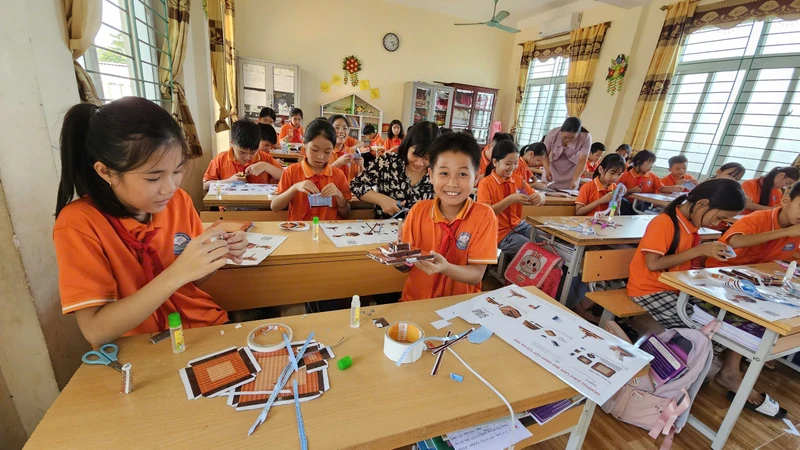 Học sinh Trường tiểu học Đại Đồng, huyện Vĩnh Tường phấn khích với mô hình Cột cờ Hà Nội của Báo Nhân Dân tặng. 