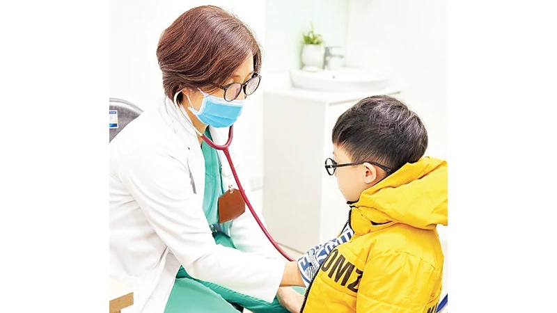 Bác sĩ Bệnh viện Hữu nghị Việt Nam - Cu Ba khám sàng lọc cho trẻ khi đến tiêm chủng. 