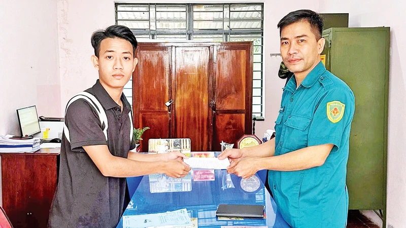 Em Mã Thành Long (trái) nộp đơn tình nguyện nhập ngũ. 