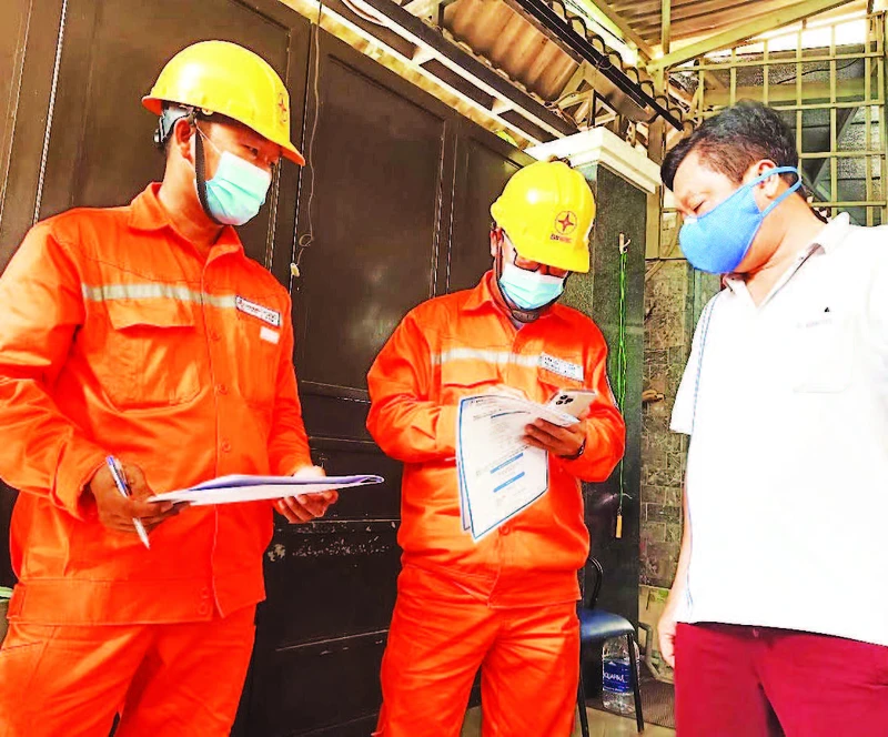 Công nhân Công ty Điện lực thành phố Thủ Đức hướng dẫn người dân sử dụng điện an toàn. 