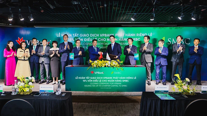 Đại diện lãnh đạo hai ngân hàng trao đổi văn kiện chứng nhận hoàn tất thương vụ phát hành cổ phiếu riêng lẻ.
