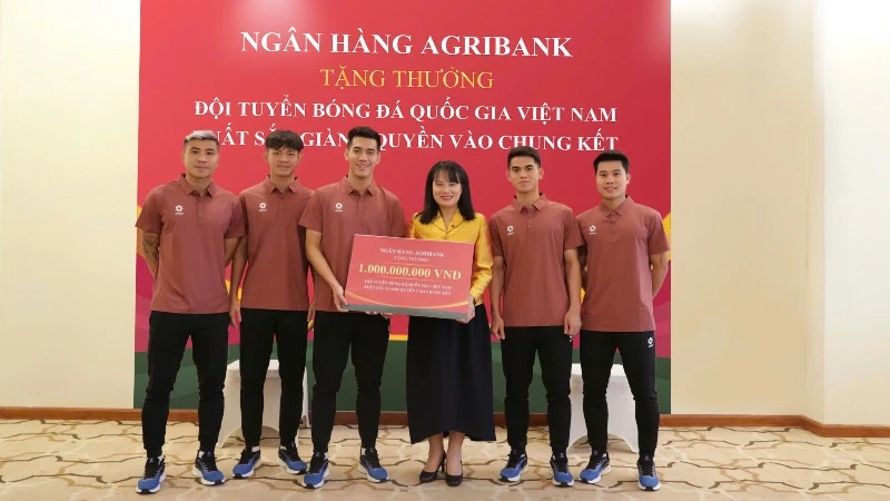 Bà Phùng Thị Bình - Phó Tổng Giám đốc Agribank trao thưởng 1 tỷ đồng cho đại diện Đội tuyển bóng đá quốc gia Việt Nam.