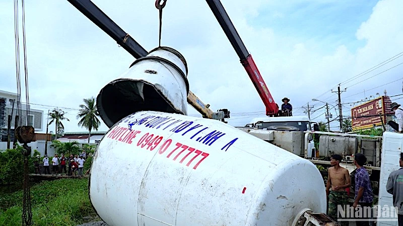 Lực lượng làm nhiệm vụ cắt thùng bê-tông để giải cứu chiếc xe lật nằm chắn ngang tuyến Quốc lộ 63. 
