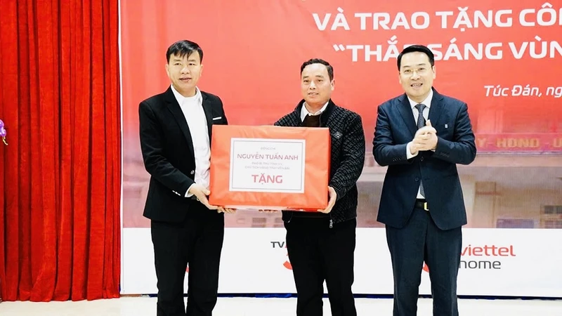 Chủ tịch Ủy ban nhân dân tỉnh Nguyễn Tuấn Anh tặng quà nhân dân xã Túc Đán. (Ảnh: THANH SƠN)