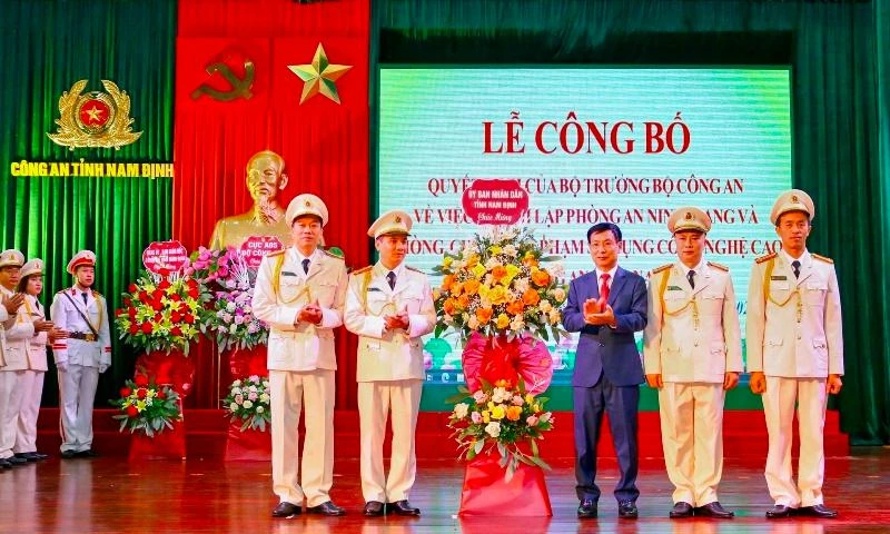 Đồng chí Phạm Đình Nghị, Chủ tịch UBND tỉnh Nam Định tặng hoa chúc mừng đại diện Phòng An ninh mạng và phòng, chống tội phạm sử dụng công nghệ cao thuộc Công an tỉnh.