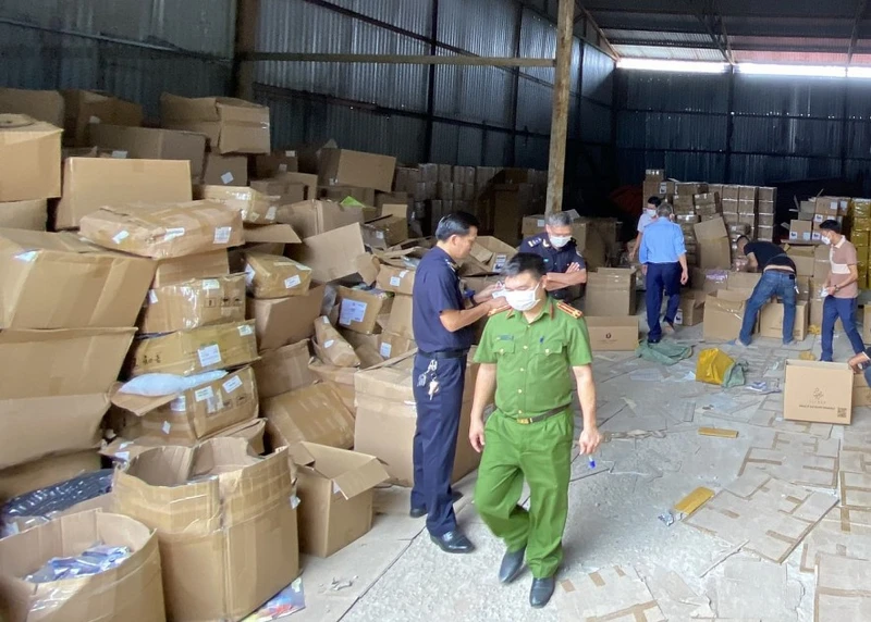 Các lực lượng chức năng kiểm tra kho hàng. ( Ảnh: CAND)