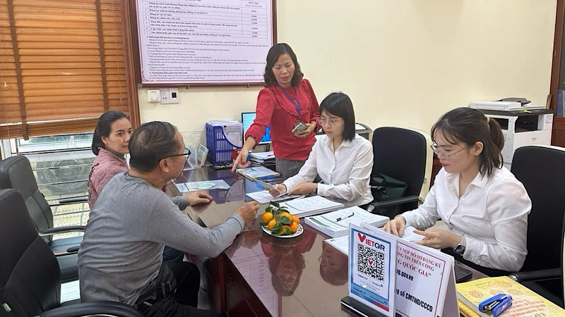 Cán bộ ngân hàng hướng dẫn người dân mở tài khoản để thực hiện chi trả an sinh xã hội không dùng tiền mặt. 