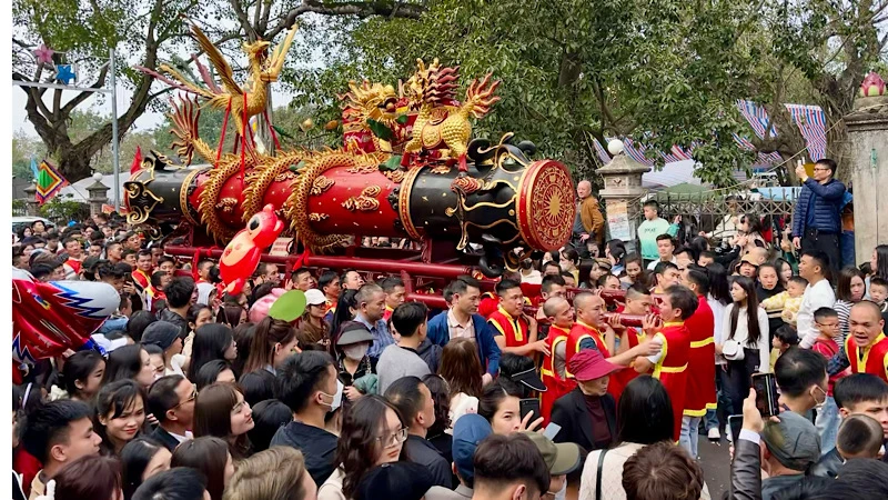 Người dân trong làng và du khách hân hoan rước pháo ra đình.