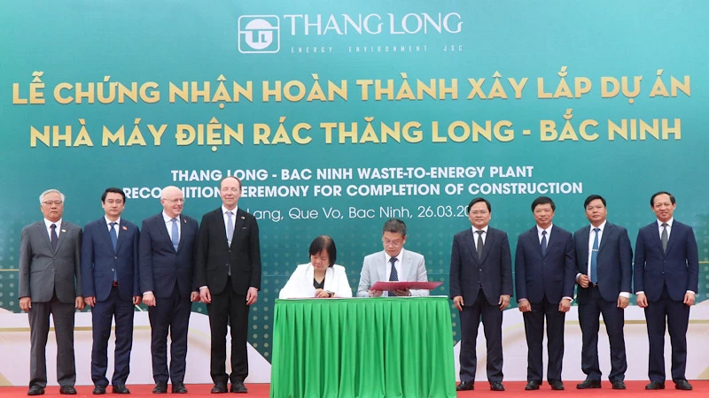 Các đại biểu chứng kiến lễ ký kết bàn giao chứng nhận hoàn thành xây lắp dự án nhà máy.