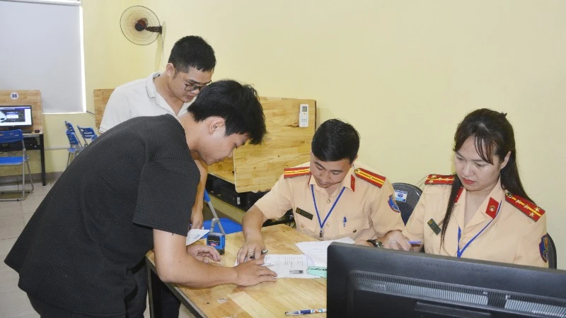 Cán bộ Phòng Cảnh sát Giao thông hướng dẫn học viên thủ tục thi.