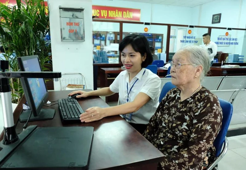 Cán bộ Ủy ban nhân dân quận Bắc Từ Liêm (Hà Nội) hướng dẫn người dân giải quyết thủ tục hành chính. (Ảnh: CÔNG HÙNG)