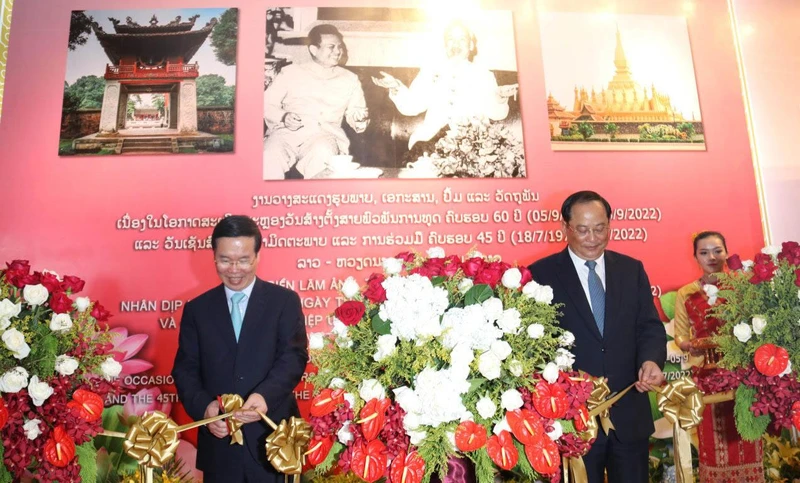 Đồng chí Võ Văn Thưởng (trái) và và đồng chí Sonsay Siphandone cắt băng khai mạc cuộc triển lãm, chiều 17/7.