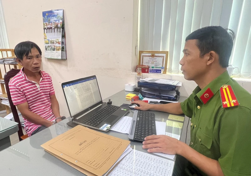 Cán bộ điều tra lấy lời khai nghi can Lê Huy Dũng.