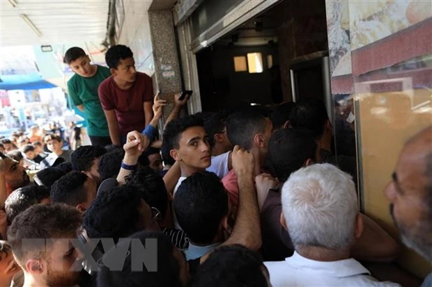 Người dân xếp hàng chờ nhận thức ăn cứu trợ tại Dải Gaza. (Ảnh: THX/TTXVN)