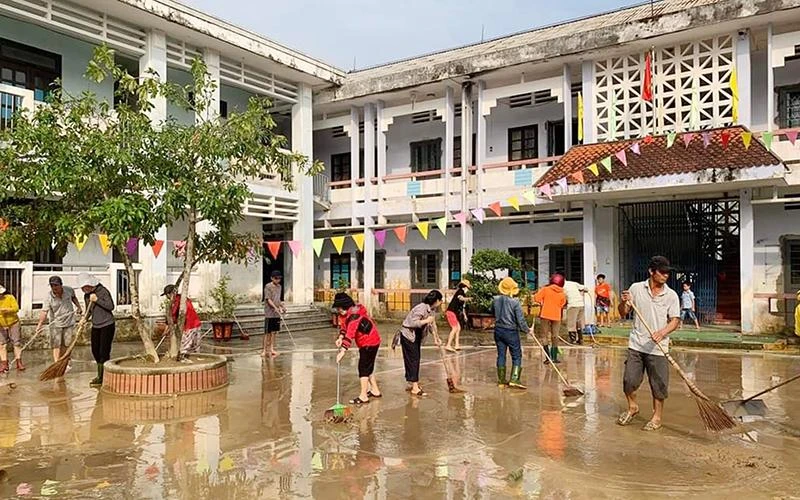 Giáo viên và phụ huynh Trường tiểu học-THCS Hải Hòa (huyện Hải Lăng, tỉnh Quảng Trị) dọn vệ sinh trường lớp để đón học sinh trở lại vào sáng 19/10. (Ảnh QUANG HUY)