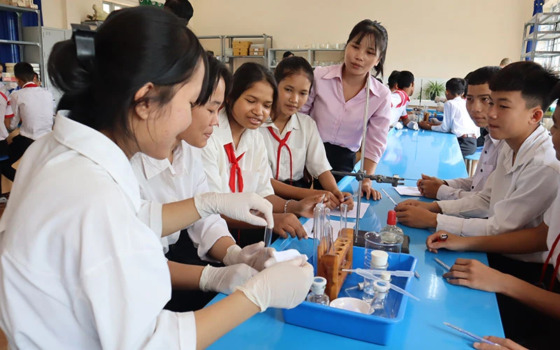 Cô và trò Trường THCS Cư Pui (Krông Bông, Đắk Lắk) trong giờ thực hành môn Hóa học. (Ảnh Xuân Kỳ)