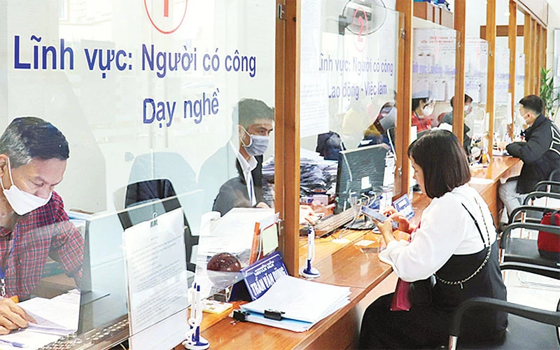 Giải quyết thủ tục hành chính cho người dân tại Bộ phận một cửa Sở Lao động-Thương binh và Xã hội Hà Nội. (Ảnh Quang Thái)