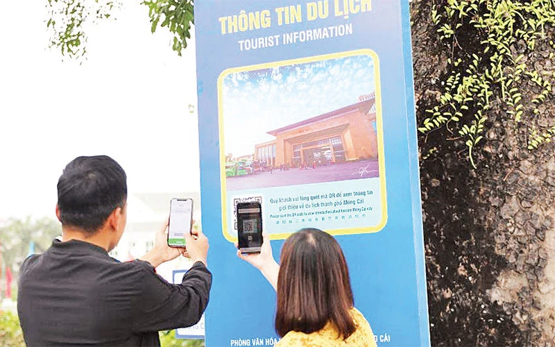 Du khách quét mã QR để cập nhật thông tin về du lịch tại Khu du lịch ở mũi Sa Vĩ, Móng Cái.