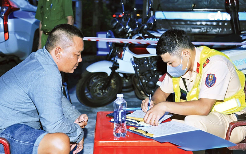 Lực lượng Công an tỉnh Đồng Nai lập biên bản xử lý lái xe vi phạm trật tự an toàn giao thông trên Quốc lộ 20.