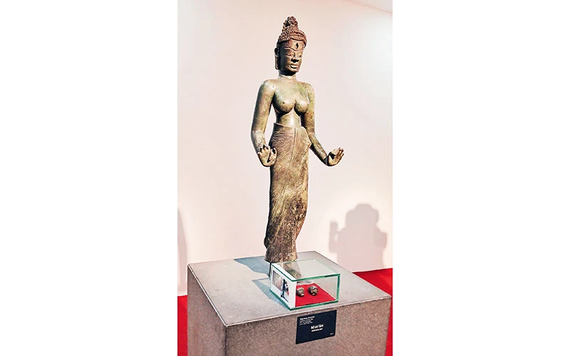 Tượng Bồ tát Tara và hai di vật đóa sen và con ốc trong hộp kính đặt dưới chân tượng. (Ảnh do Bảo tàng Điêu khắc Chăm cung cấp)
