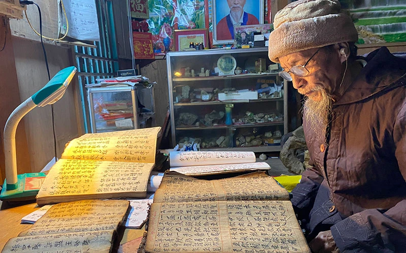 Già Đặng Hành Phi, xã Tân Lập (huyện Chợ Đồn) tự học và sưu tầm tài liệu chữ Nôm Dao. (Ảnh MINH TÂM)