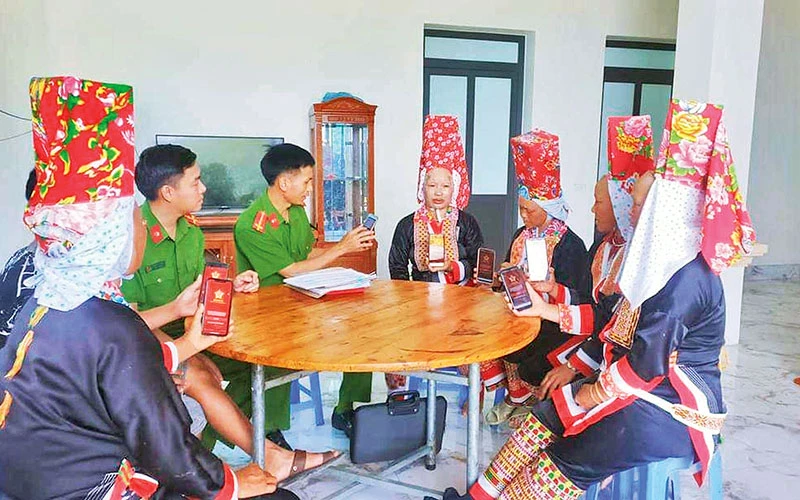 Công an xã Lục Hồn, huyện Bình Liêu (Quảng Ninh) hướng dẫn người dân cài đặt ứng dụng VneID trên điện thoại thông minh.