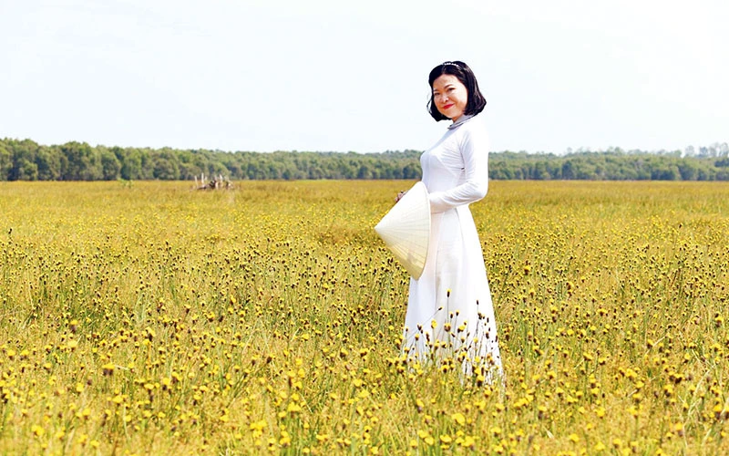 Du khách với hoa hoàng đầu ấn. (Ảnh LÊ THÀNH TRÍ)