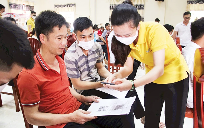 Nhân viên bưu điện Lạng Sơn hướng dẫn người dân ở xã Chi Lăng, huyện Chi Lăng ứng dụng chuyển đổi số, đưa nông sản lên sàn thương mại điện tử.