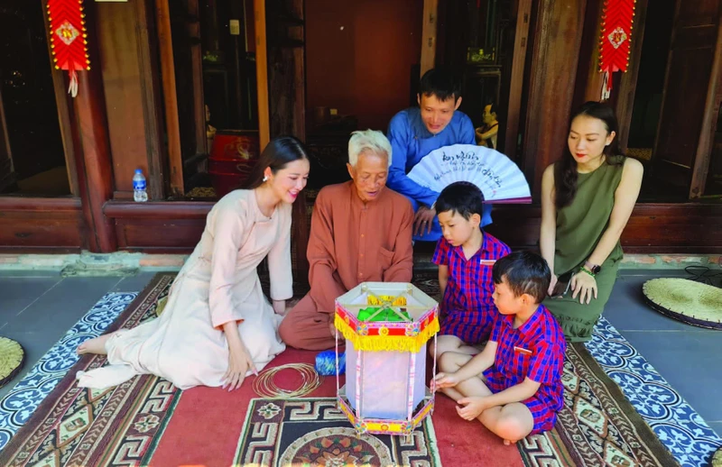 Nghệ nhân Nguyễn Văn Quyền (thứ hai từ trái sang; xã Cao Viên, huyện Thanh Oai, Hà Nội) giới thiệu cách làm đèn kéo quân. 