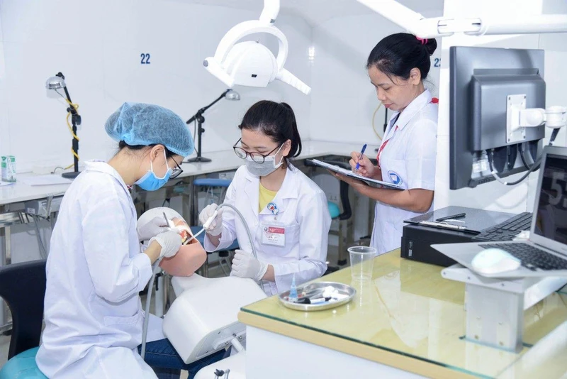 Hướng dẫn sinh viên chuyên ngành răng hàm mặt Trường đại học Y Hà Nội thực tập trên mô hình mô phỏng hàm răng người.