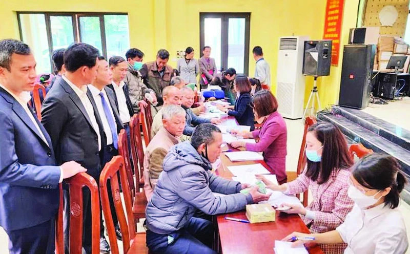 Chi trả tiền hỗ trợ bồi thường giải phóng mặt bằng cho các hộ gia đình có đất nằm trong chỉ giới thu hồi phục vụ dự án đường vành đai 4 - Vùng Thủ đô tại xã Song Phương, huyện Hoài Đức. (Ảnh: TRẦN THỤ)