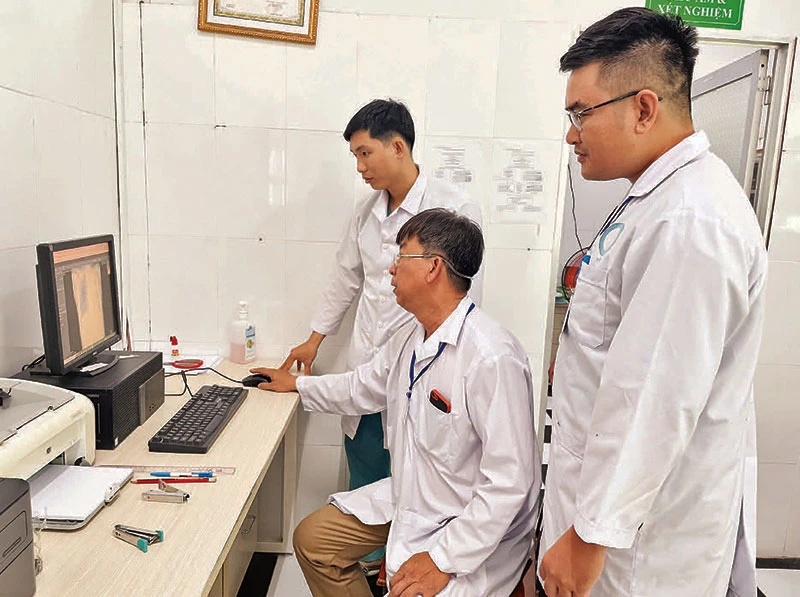 Các bác sĩ Trạm Y tế xã Thạnh An chẩn đoán tình trạng bệnh từ hình ảnh trên máy tính.