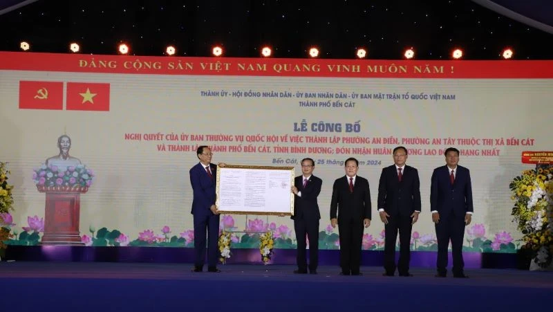Phó Chủ tịch Quốc hội Trần Quang Phương (bên trái) trao Quyết định thành lập thành phố Bến Cát.