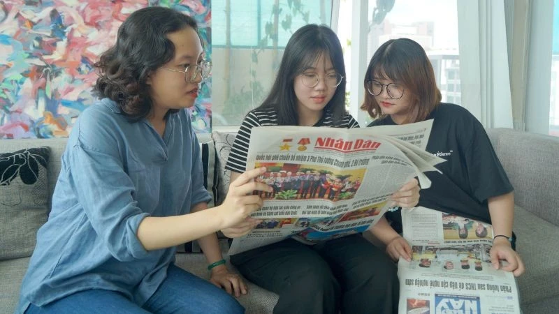 Các bạn trẻ tại Thành phố Hồ Chí Minh đón đọc Báo Nhân Dân. (Ảnh: THẾ ANH)