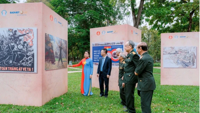 Họa sĩ Nguyễn Thu Thủy giới thiệu tác phẩm tới các cựu chiến binh tham quan triển lãm. (Ảnh: AN HẢI)