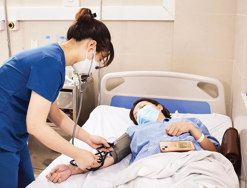 Điều trị bệnh nhân cúm A tại Bệnh viện Đa khoa Thanh Nhàn. Ảnh: CHI LÊ