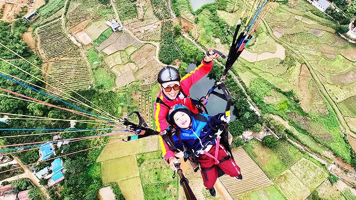 Một em nhỏ trải nghiệm bay dù lượn. Ảnh: MEBAYLUON PARAGLIDING