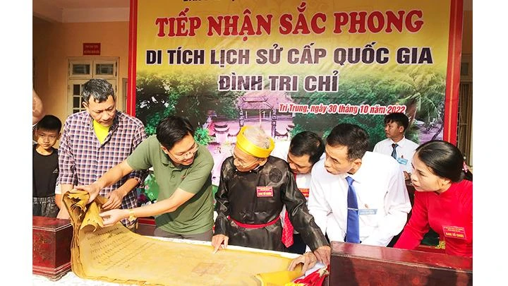Nhà sưu tầm Đặng Vũ Khương (áo kẻ) và nhà nghiên cứu Nguyễn Đức Dũng cùng đại diện xã, thôn kiểm tra các đạo sắc phong.