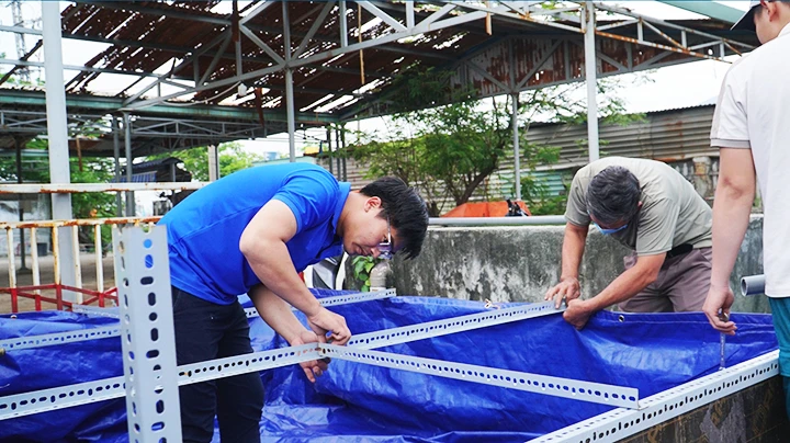 Quốc Vương (bên trái) đang lắp đặt bể lọc di động tại một đơn vị.