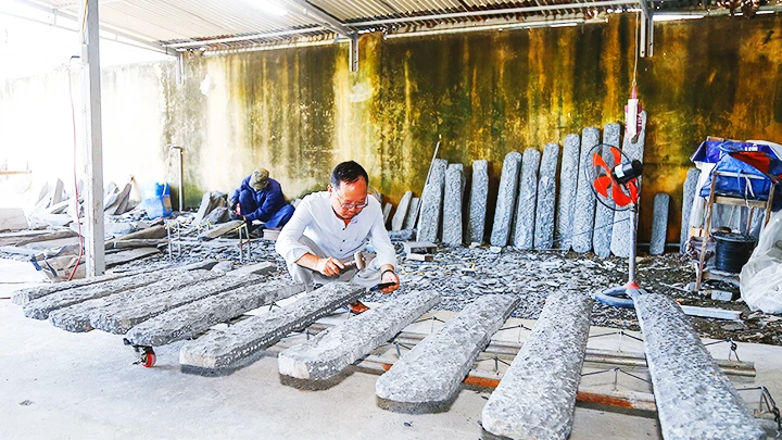 Nhạc sĩ Phương Đông chế tác đàn đá mới. Ảnh: ĐÌNH LÂM